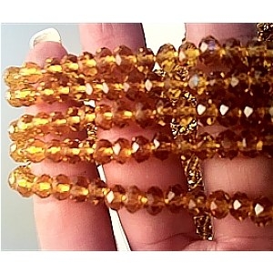 Glass Beads 6mm Faceted Amber bd606 closeup image with hand